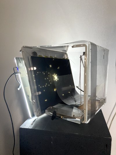 Photograph of a sculptural light box, a screen of stars mounted on a metal plinth.