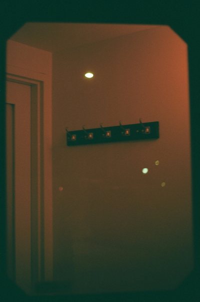 Photograph of a dim interior in teal and orange, a doorway standing open at the left.