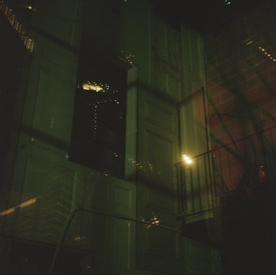 Night photograph of a building's lit windows seen through a heavy green cast.